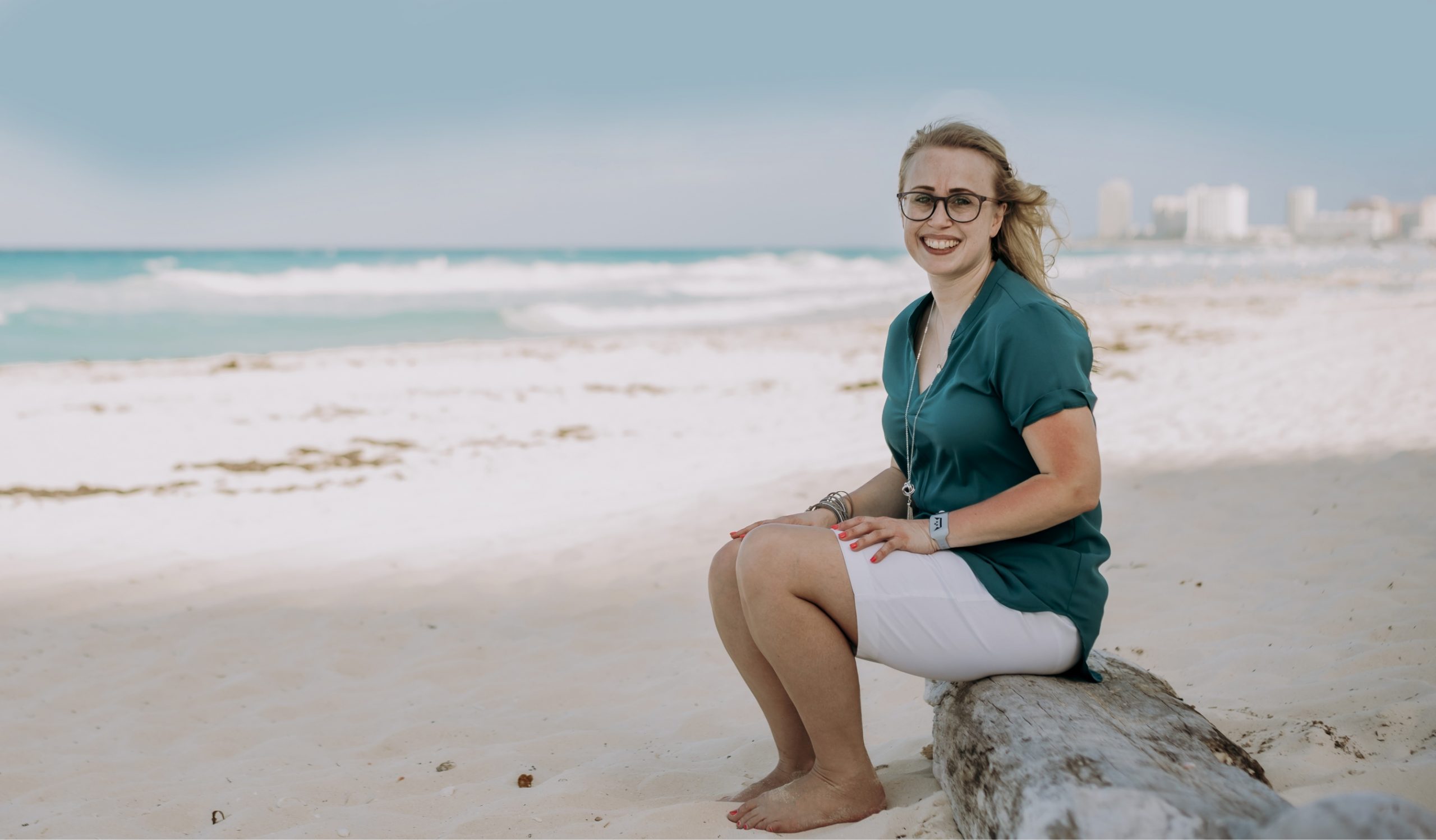 Kendra sitting on a log